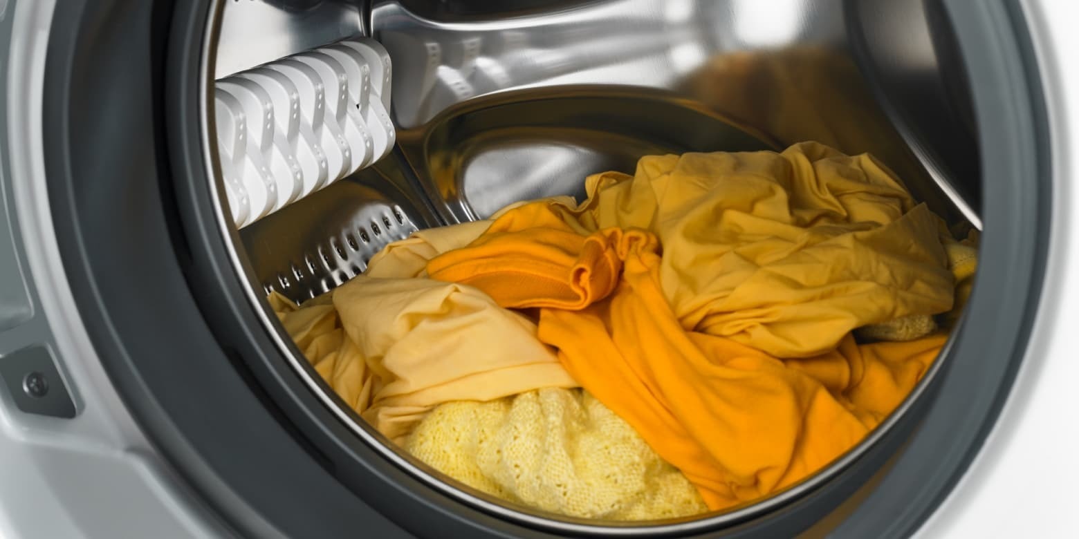 Yellow clothing inside an open appliance drum in the source shrinkage guide.